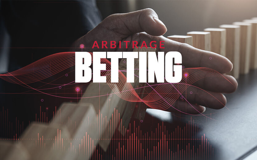 arbitrage betting text overlay on hand stopping dominoes from falling