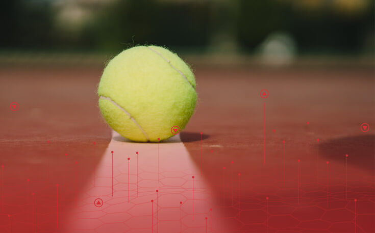 close up image of a tennis ball sitting on the line on a court