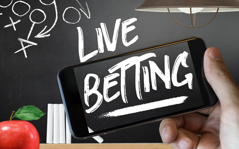 Live betting written on betting 101 chalkboard and cell phone