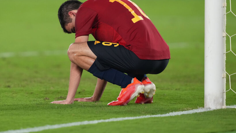 Spain forward Dani Olmo crouching on the field