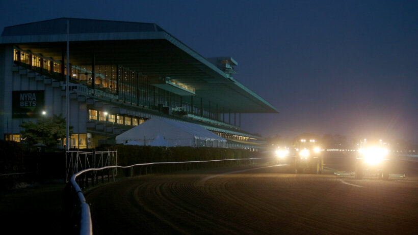 Tractors harrow the track before morning workouts at Belmont Park.