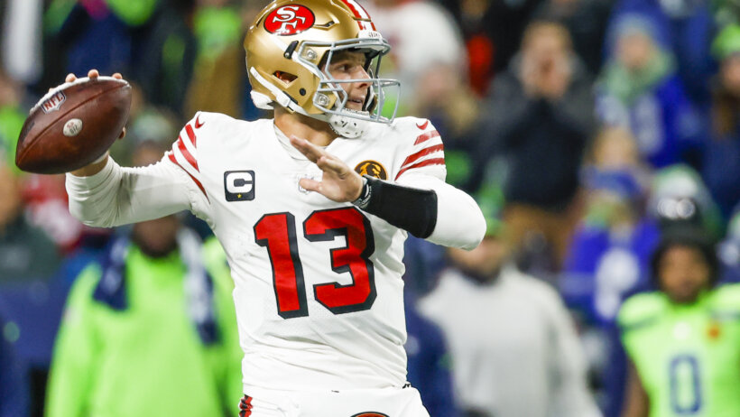 San Francisco 49ers football player Brock Purdy throwing a football.