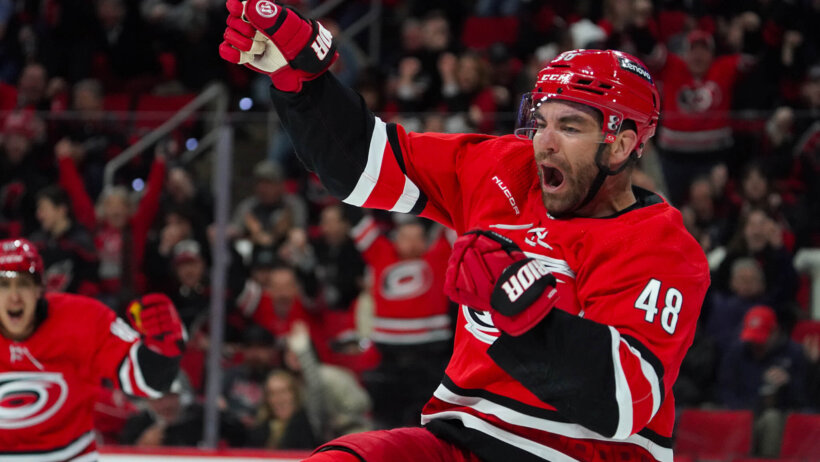 Carolina Hurricanes player Jordan Martinook celebrating goal arms raised red jersey