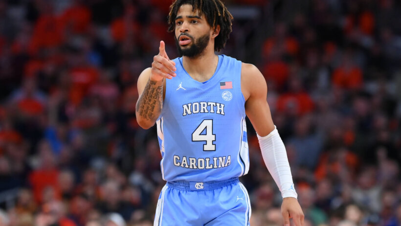 North Carolina Tar Heels college basketball player RJ Davis pointing blue jersey