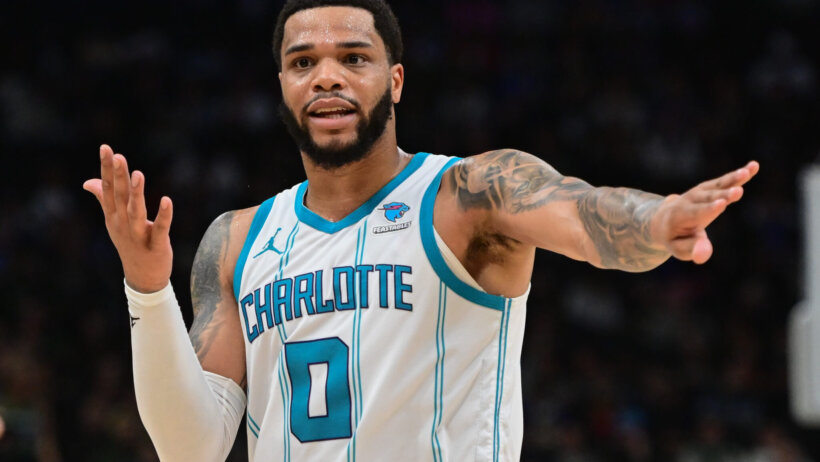 Charlotte Hornets player Miles Bridges pointing white and blue jersey