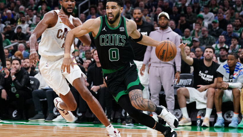 Boston Celtics forward Jayson Tatum dribbles around Cleveland Cavaliers forward Evan Mobley