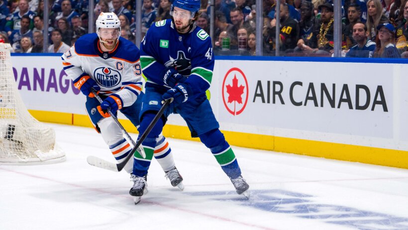 Edmonton Oilers forward Connor McDavid defends against Vancouver Canucks defenseman Quinn Hughes