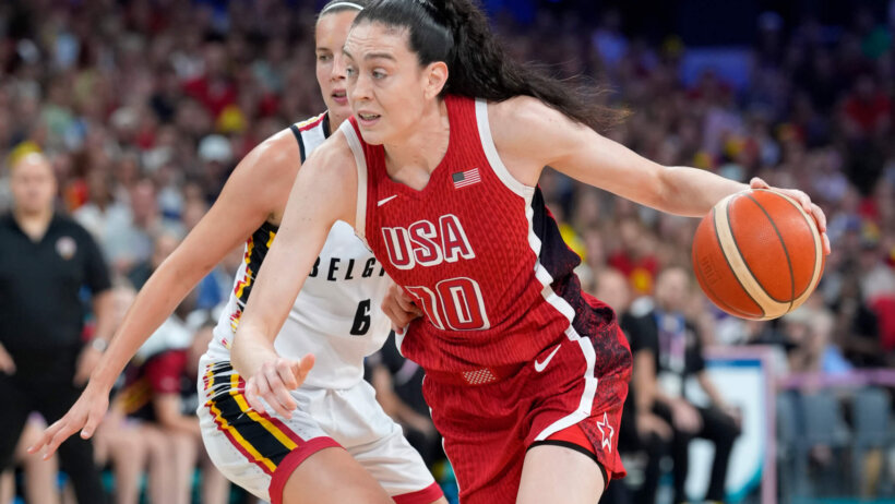 Breanna Stewart of Team USA dribbles by a Belgian defender at the 2024 Paris Olympics.