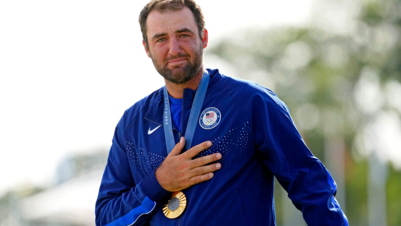 Scottie Scheffler holds his hand over his heart after winning a gold medal for Team USA at the 2024 Paris Olympics.