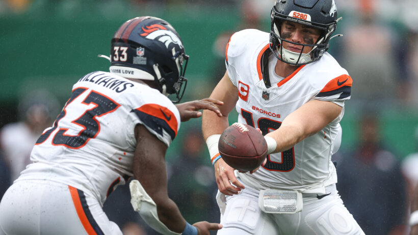 Denver Broncos quarterback Bo Nix hands a football off to teammate Javonte Williams.