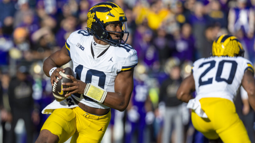 Michigan Wolverines quarterback Alex Orji runs while holding a football.