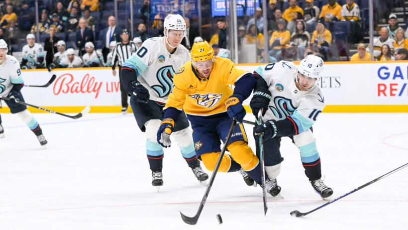 Seattle Kraken center Matty Beniers steals the puck from Nashville Predators center Jonathan Marchessault