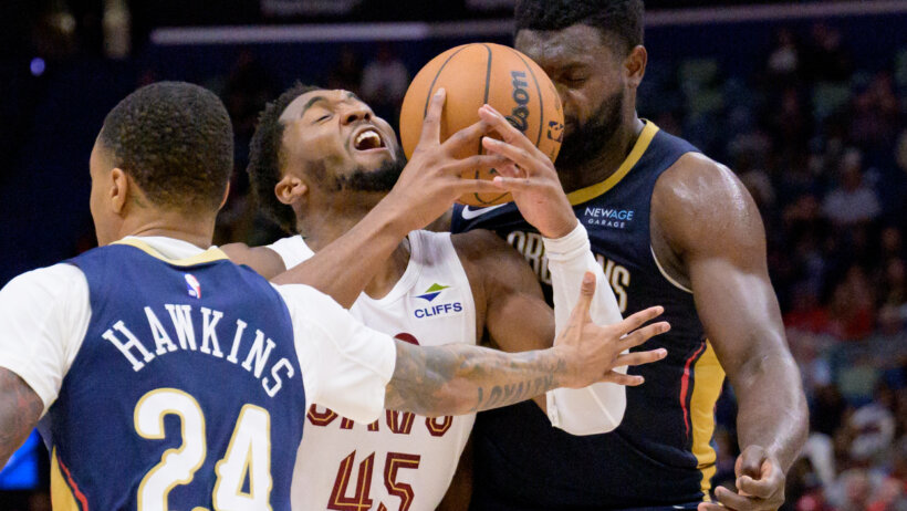 Cleveland Cavaliers guard Donovan Mitchell drives against a pair of New Orleans Pelicans defenders