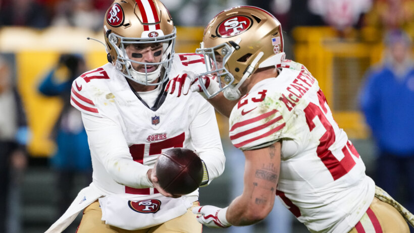 San Francisco 49ers quarterback Brandon Allen hands the football off to running back Christian McCaffrey